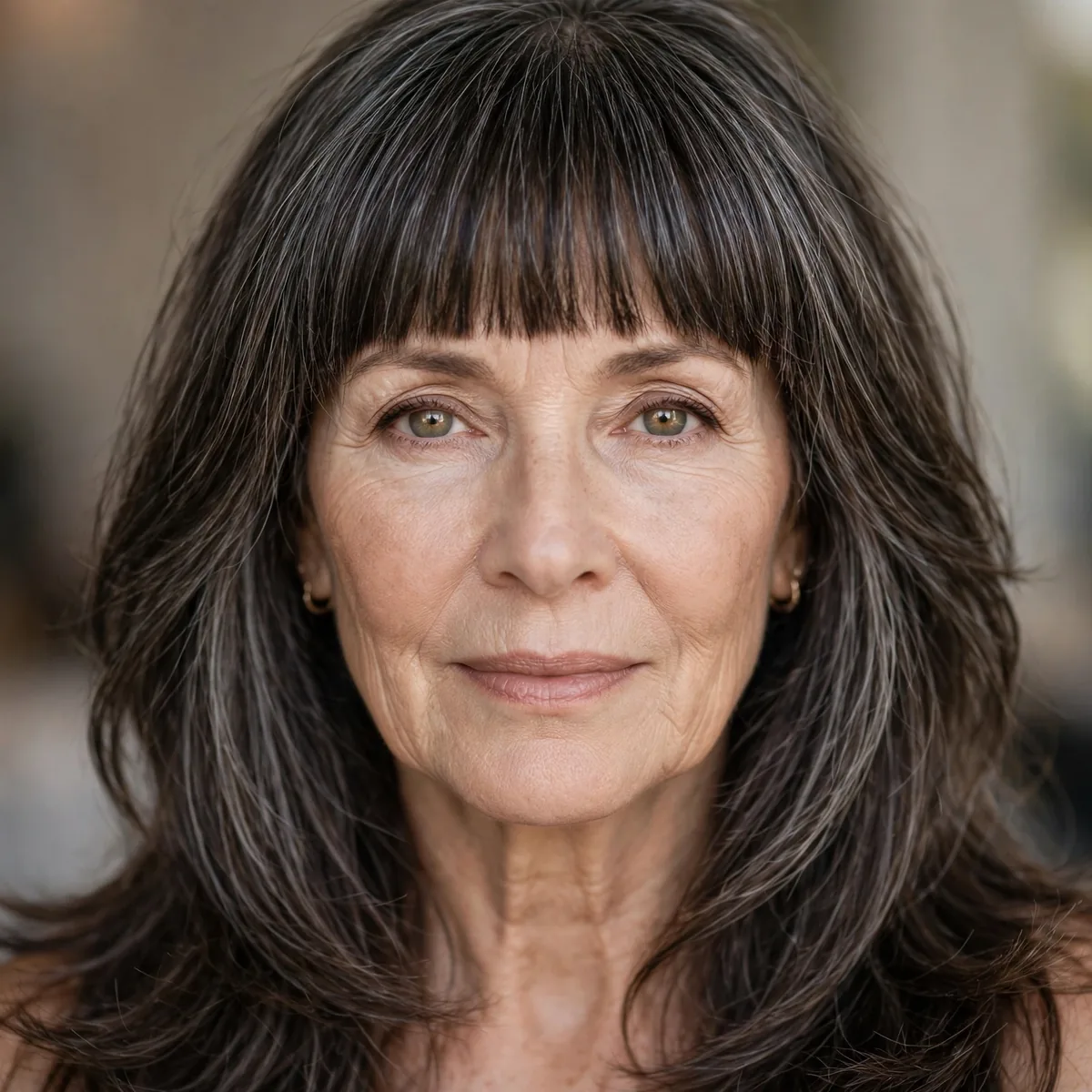 Brow skimming blunt bangs with long layered hair on an older woman
