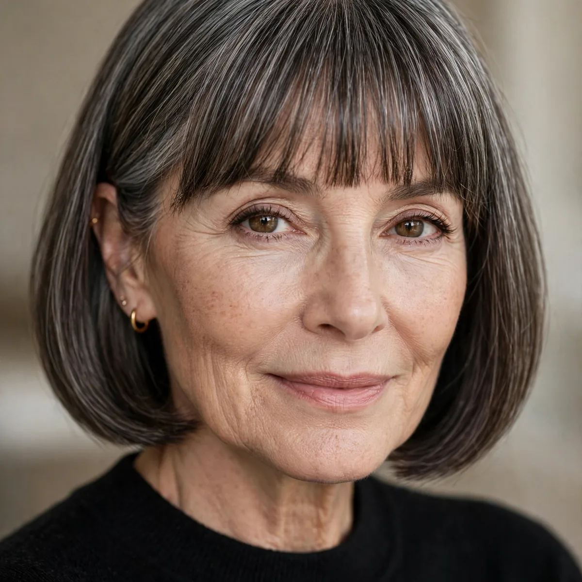 Soft blunt bangs with a sleek chin length bob for older women